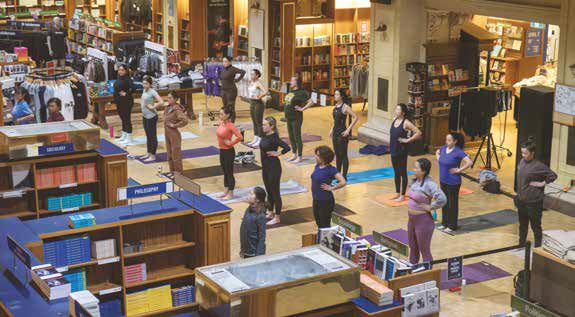 Photo of a group of people doing yoga in a bookstore